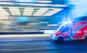 Ambulance rushes towards a scene with car accident injuries or auto accident injuries of a traumatic brain injury and soft tissue injury