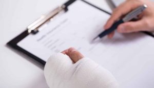 Person with auto accident injuries signs a personal injury claims and goes through the financial aspect of a PI claim with his attorney
