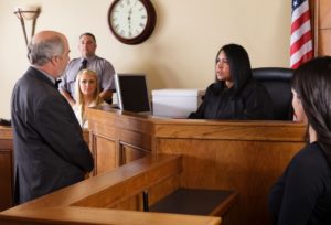 lawyer in court proving fault at the scene of an auto accident and getting a rear-end collision settlement