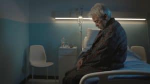 man who experienced nursing home neglect sits alone