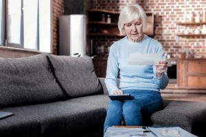 woman reading about the warning signs of nursing home abuse