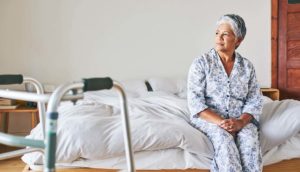 woman who suffered nursing home abuse sitting on a bed
