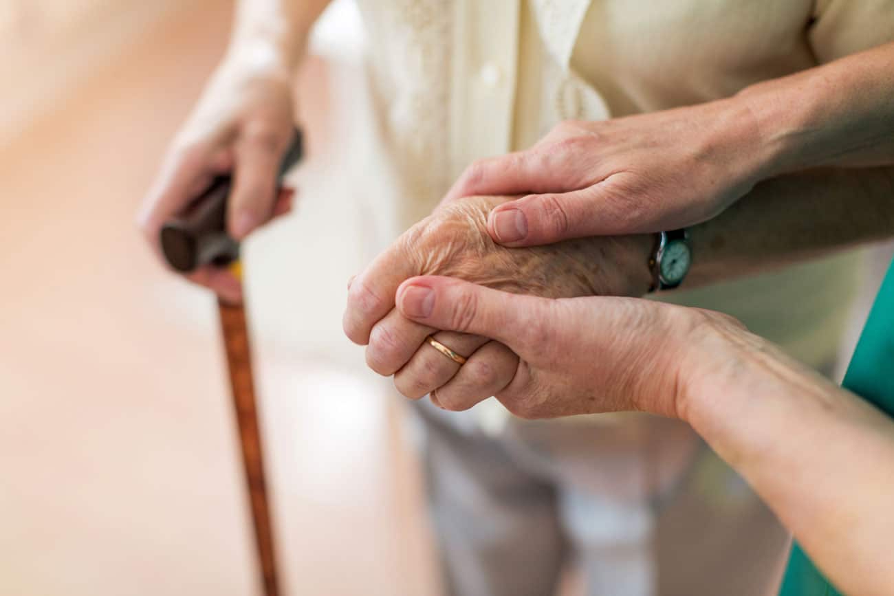 Nurse holds patients hand at nursing home