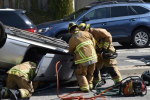 firefighters near a car after a high speed accidents/ fatal auto accident/ fatal car crash